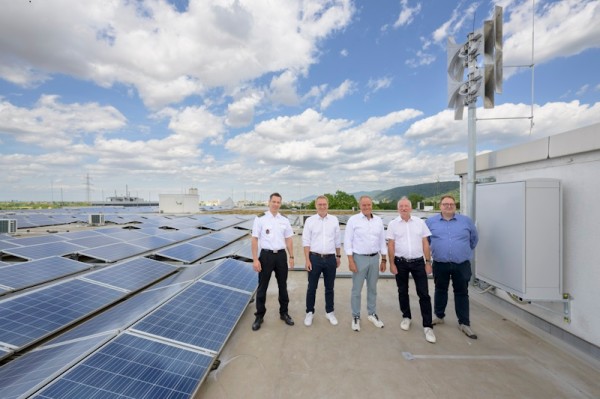 Menschen steht vor einer neuen Sirenenanlage auf einem Dach (Foto: Rote): Fünf Menschen steht vor einer neuen Sirenenanlage auf einem Dach (Foto: Rote):